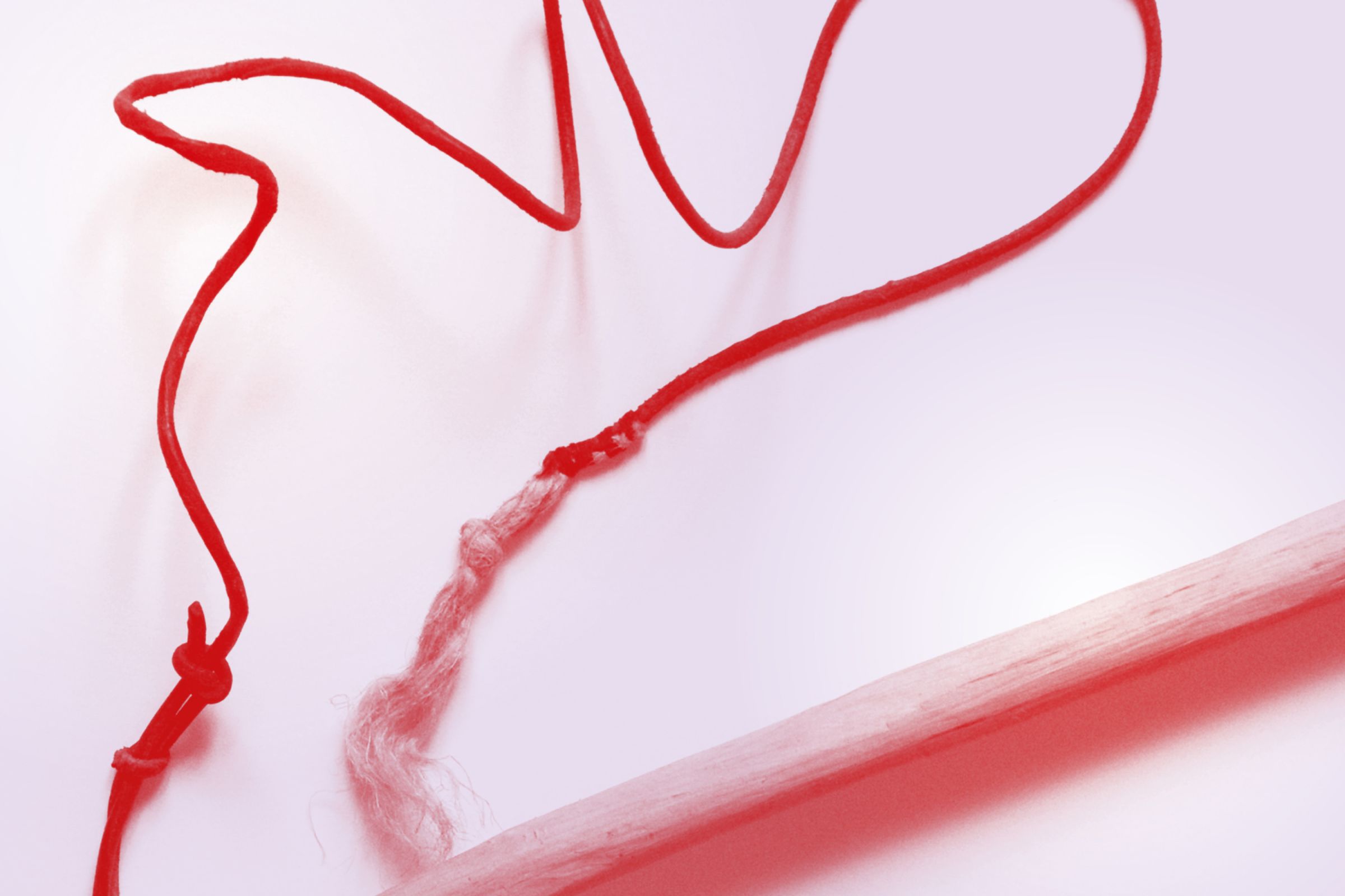 Detail von einem Stock mit einer Schnur in dunklem Rot eingefärbt