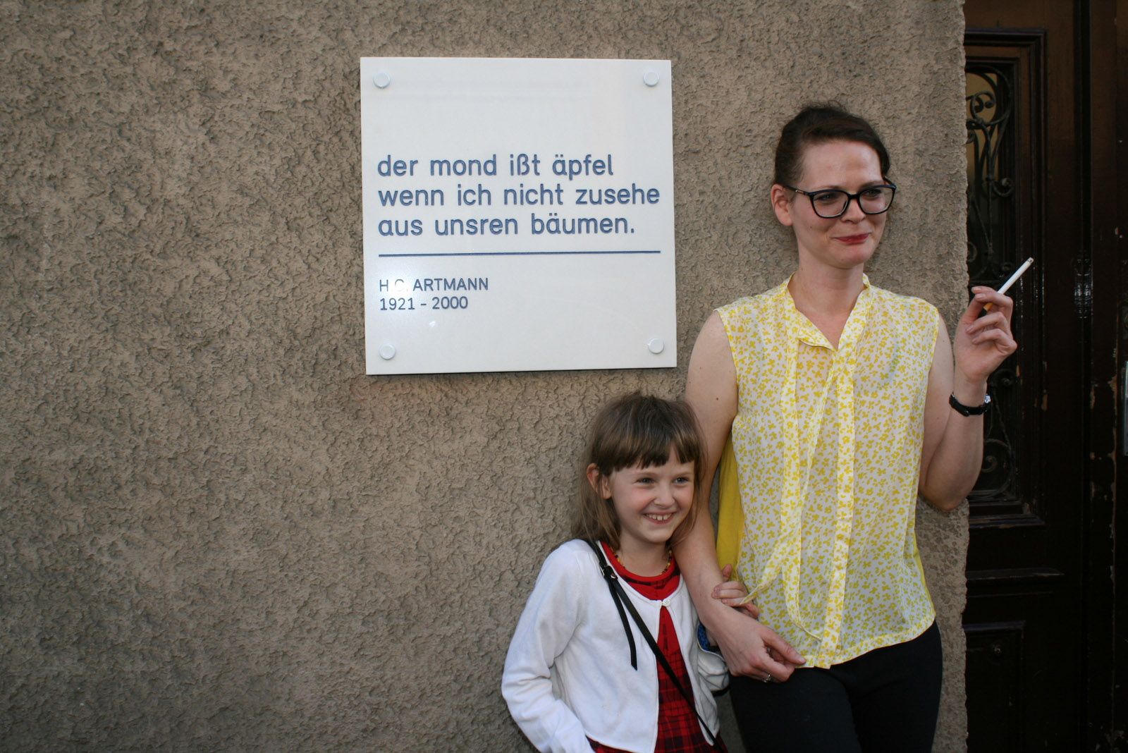 Ellis und Emily Artmann vor der HC Artmann Gedenktafel